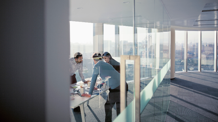 Three business people having a meeting standing over a table
